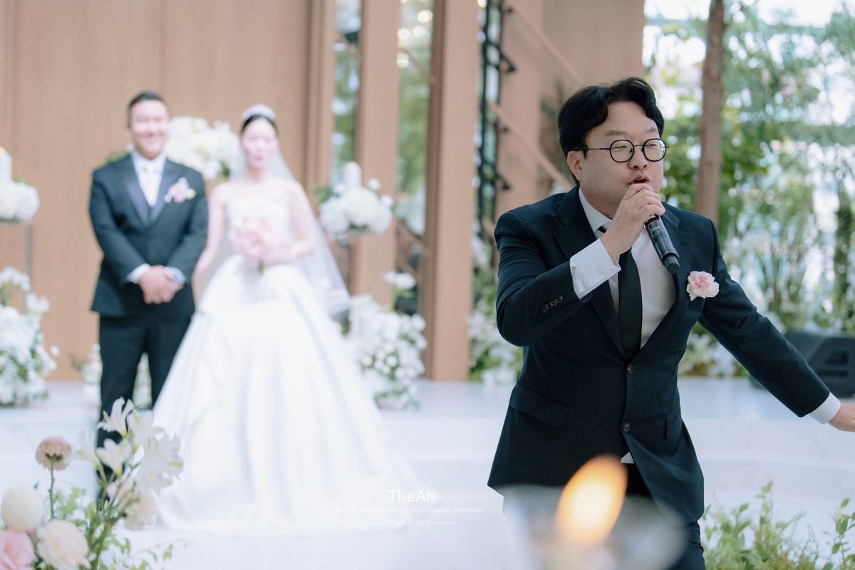 분당 바실리움 예식을 진행하는 사회자와 그 뒤에 나란히 선 신랑 신부