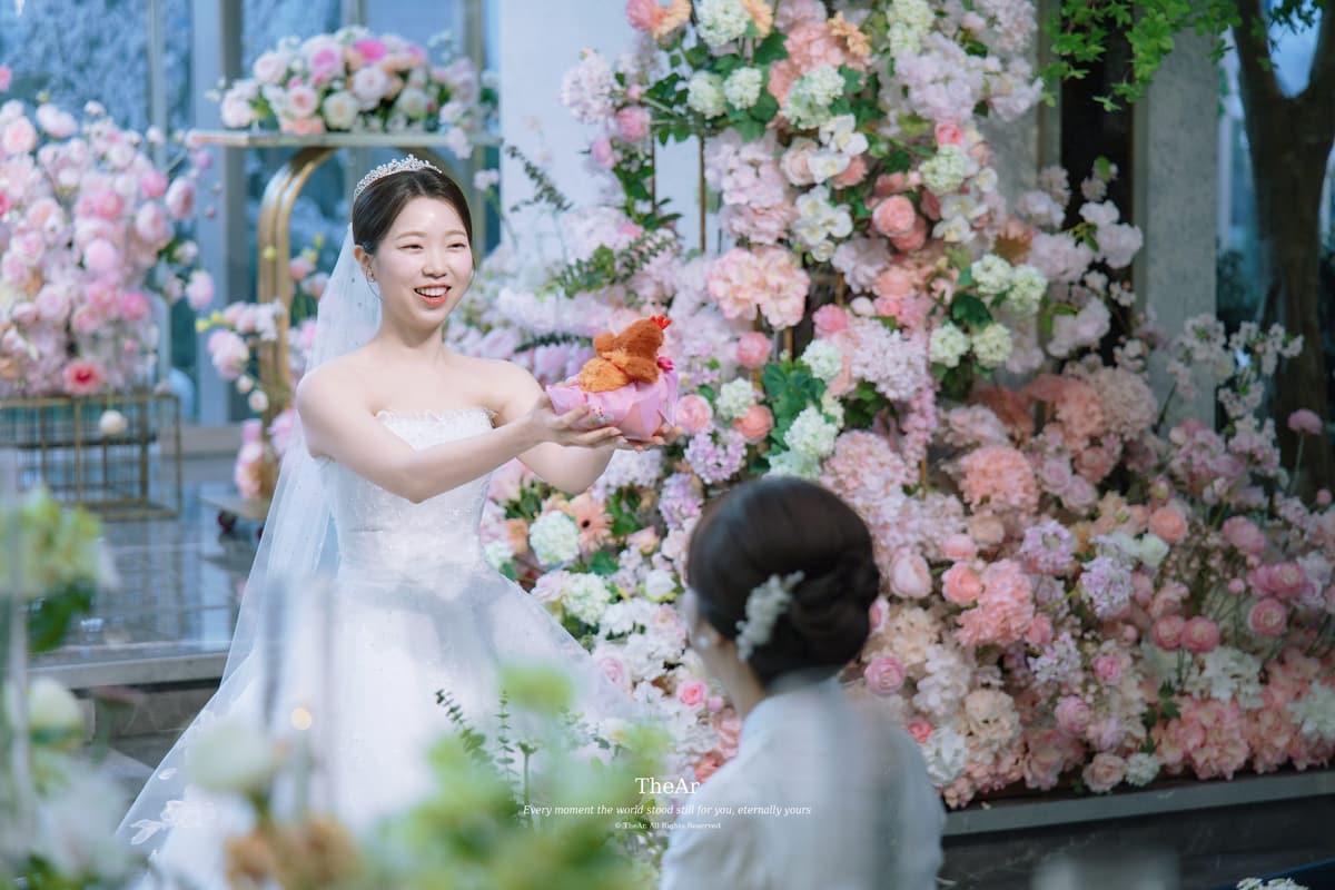 L65 가든홀 꽃 단상 앞에서 분홍 보자기에 싼 원앙을 두 손으로 들어 어머니께 건네는 신부
