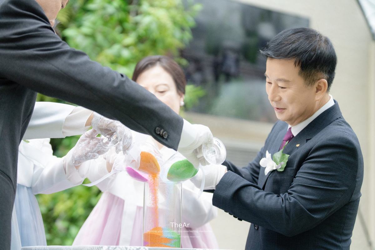 명동 라루체 웨딩홀 예식에서 색색의 모래를 한 병에 함께 부어 담는 샌드 세리머니
