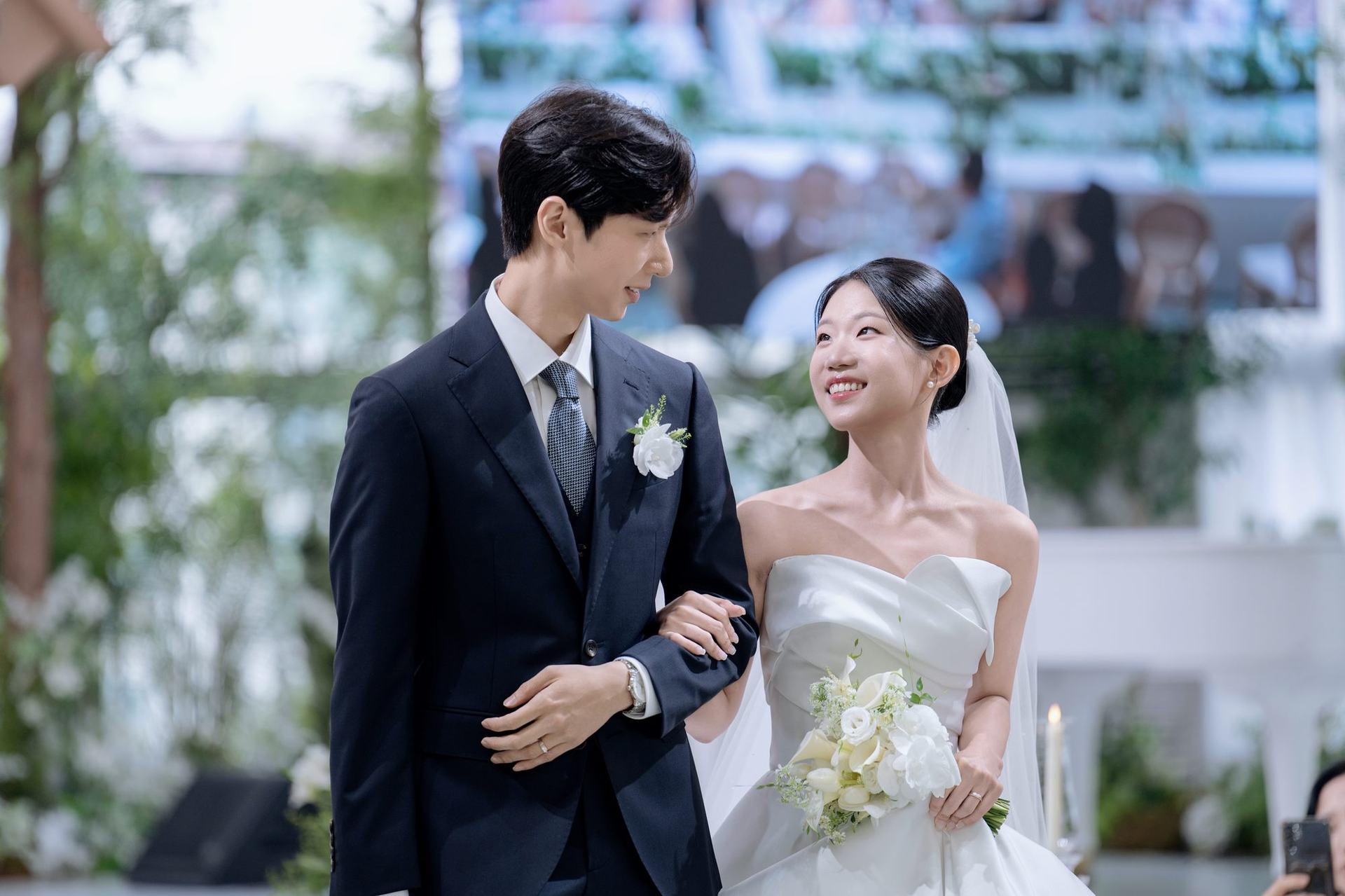 팔짱을 끼고 마주 웃는 신랑과 신부