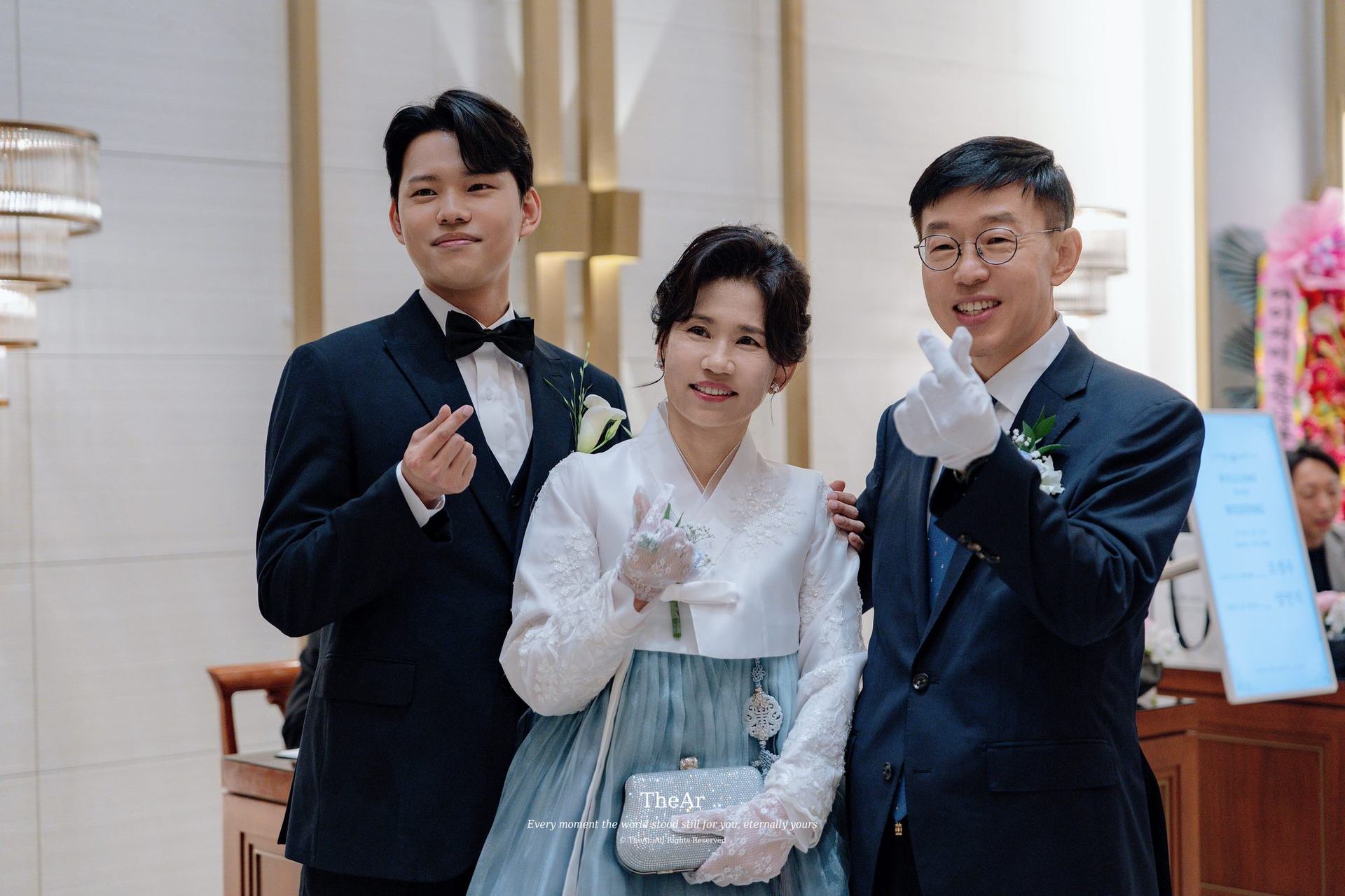 한복을 입고 가족과 나란히 서서 웃는 신부